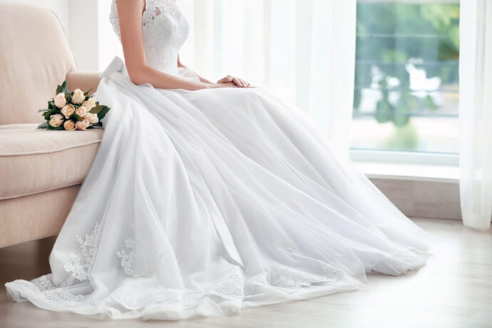 画像：ウエディングドレスを着てソファに腰掛けているパニエを履く前の花嫁