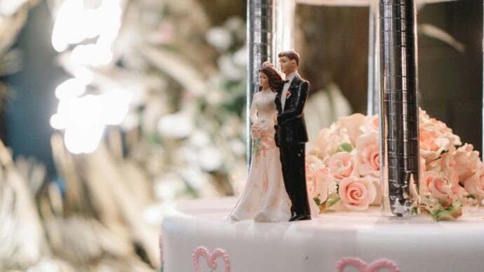 画像：ウエディングケーキに乗った花嫁と花婿のケーキトッパー
