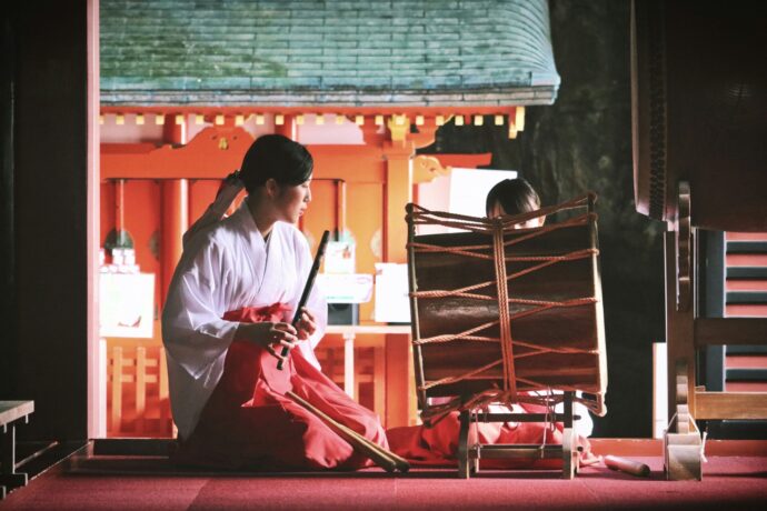 画像：神社の舞台で和太鼓を演奏する巫女