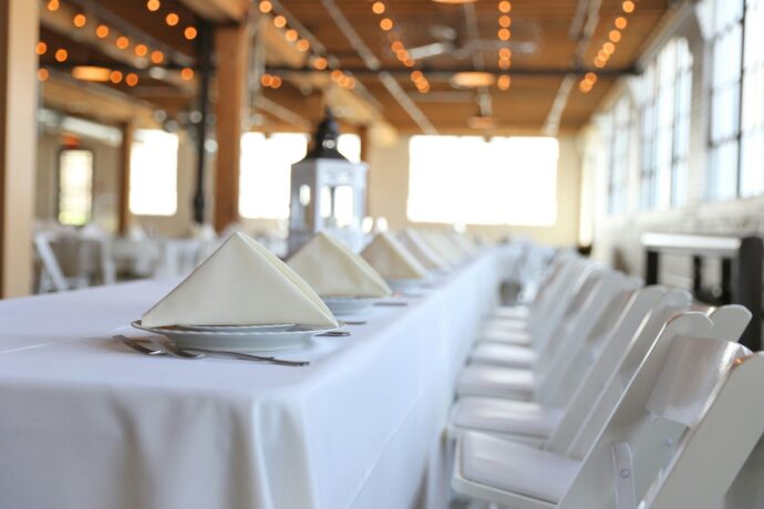 画像：白いテーブルクロスがかけられセッティングされたレストラン内
