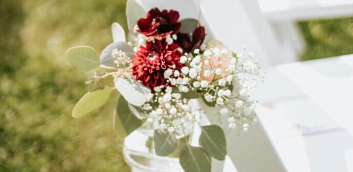 画像：ガーデンチャペルのバージンロードに置かれたイスに飾られた装花