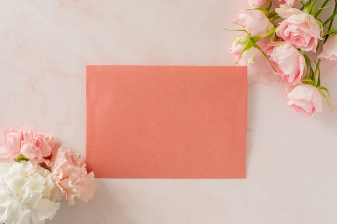 画像：ピンクの便せんとピンク系の花束2つ