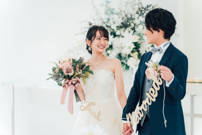 画像：手を繋ぎJust Married のガーランドを持った花嫁と花婿