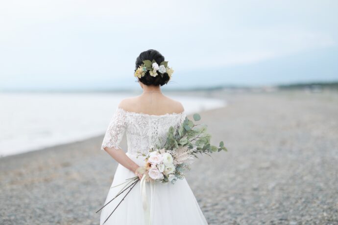 画像：白いブーケを背に持つ花嫁の後ろ姿